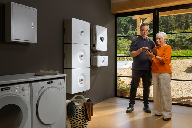 Installer standing with customer in front of SMA Home Storage Solution and giving and introduction